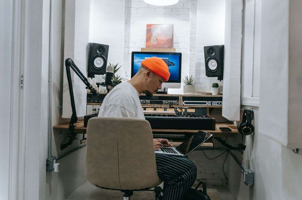 Man listening to music with speakers on desktop speaker stands