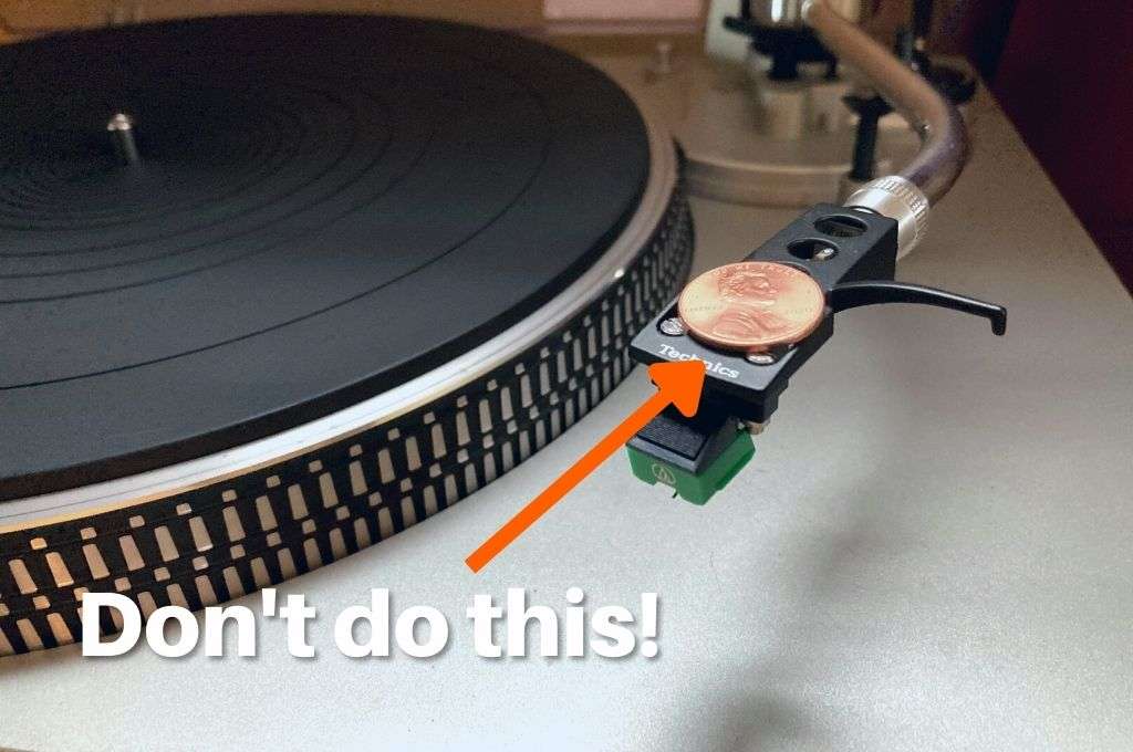The "penny method" where a penny is place on a record player stylus