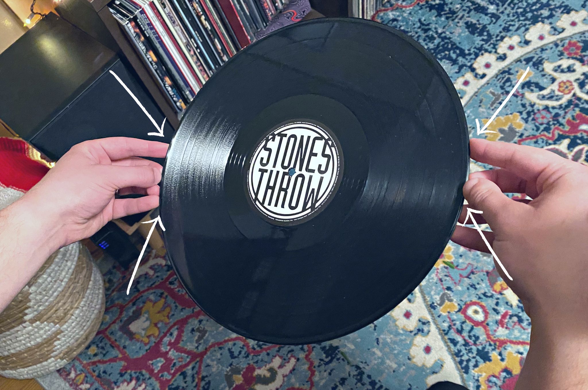 Hands holding a record on the outside edges